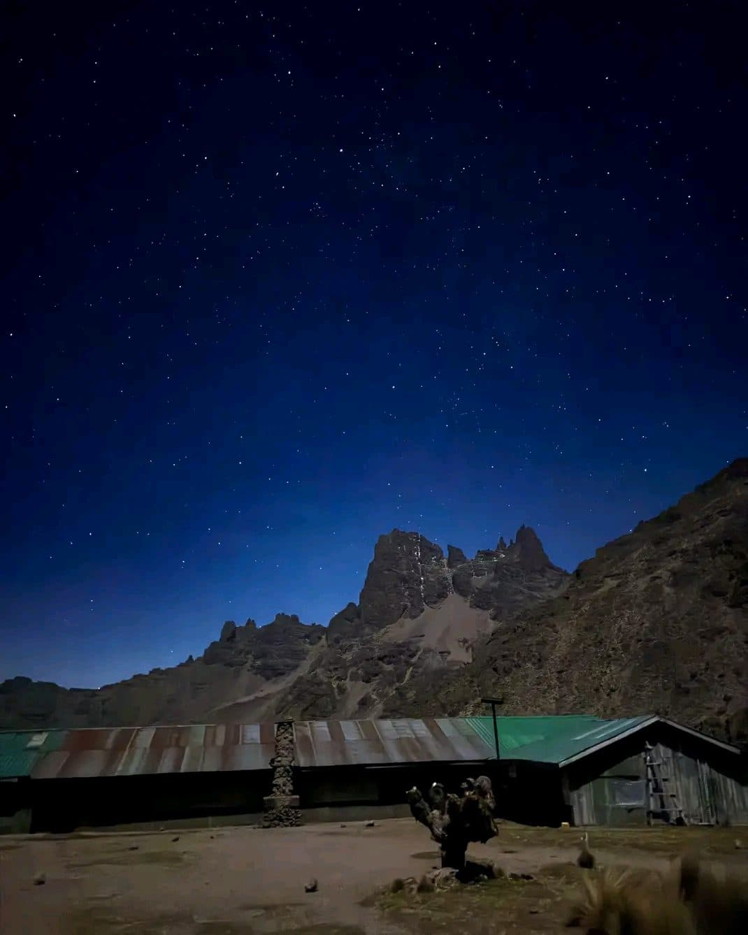 Starry night sky over Mount Kenya's peaks above a mountain hut