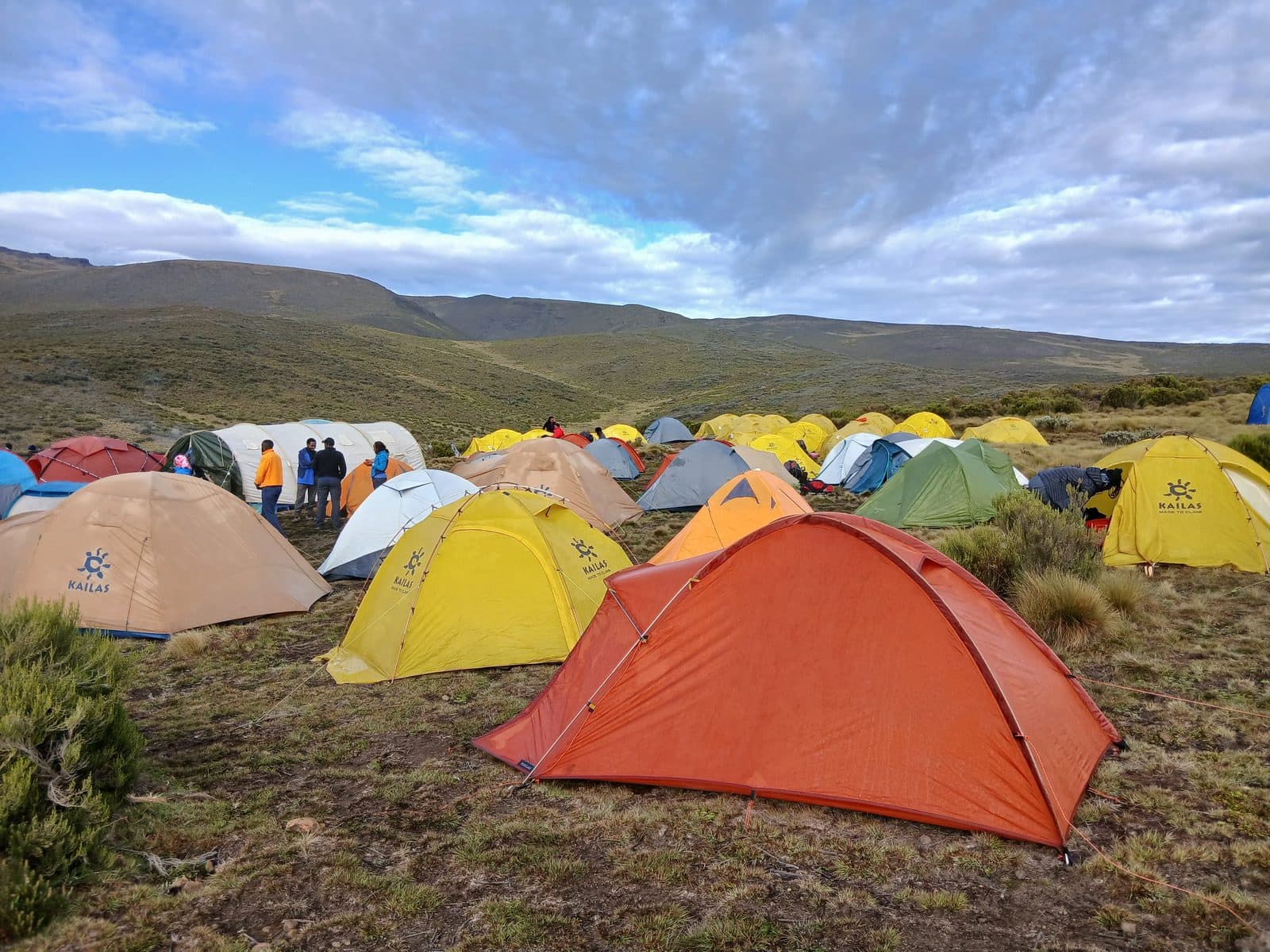 Colourful trekking tents pitched on moorland under a blue sky