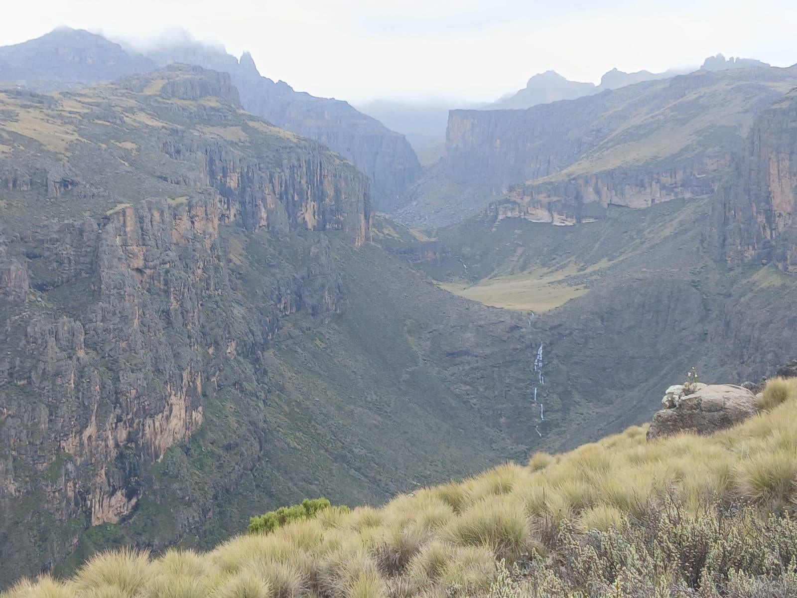 Deep cliff-lined gorge with a distant waterfall on Mount Kenya