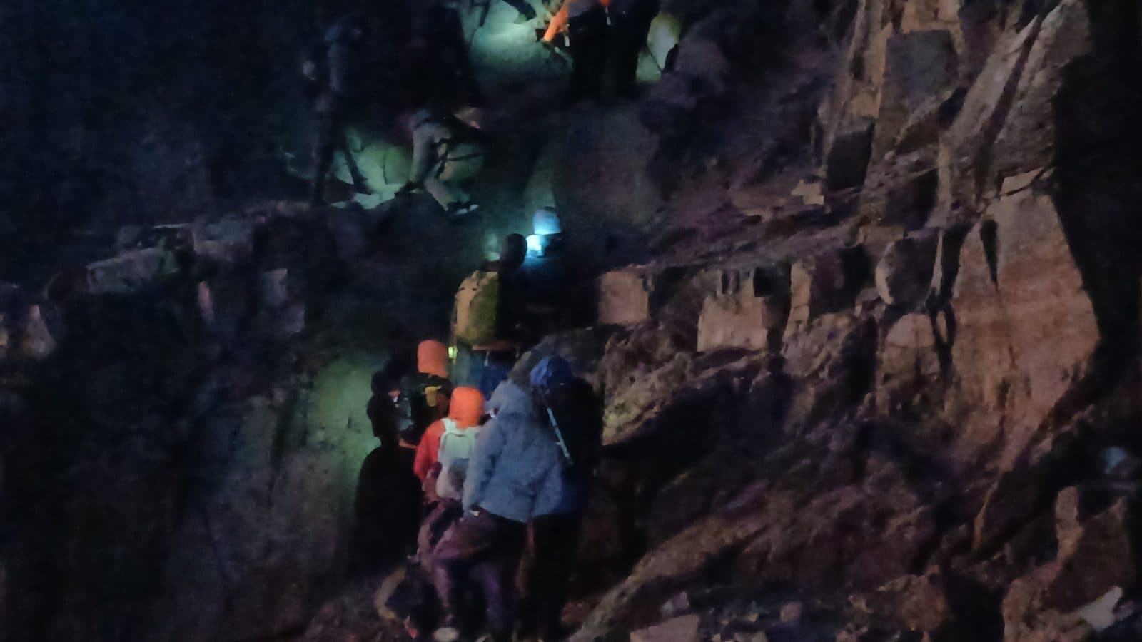 Headlamps lighting a pre-dawn scramble up the rocks