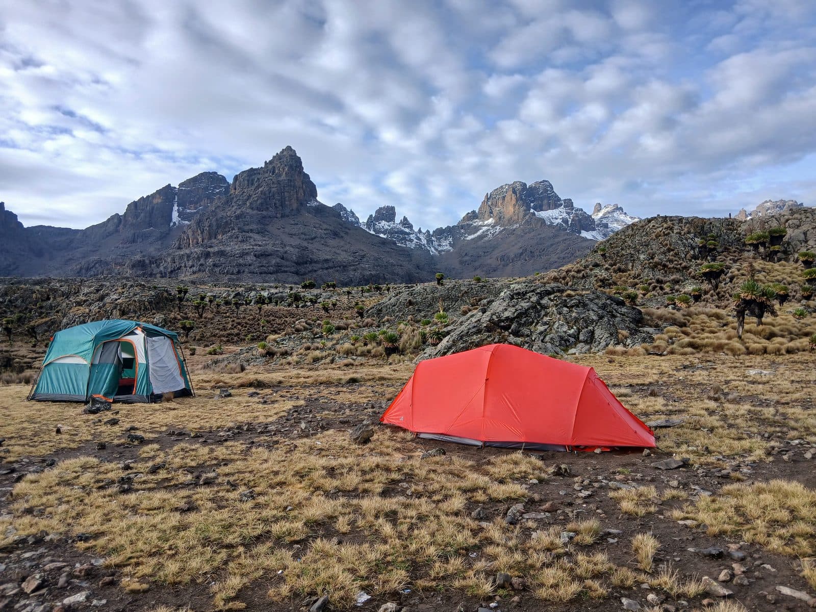 Red and green tents on the moorland below Mount Kenya's peaks