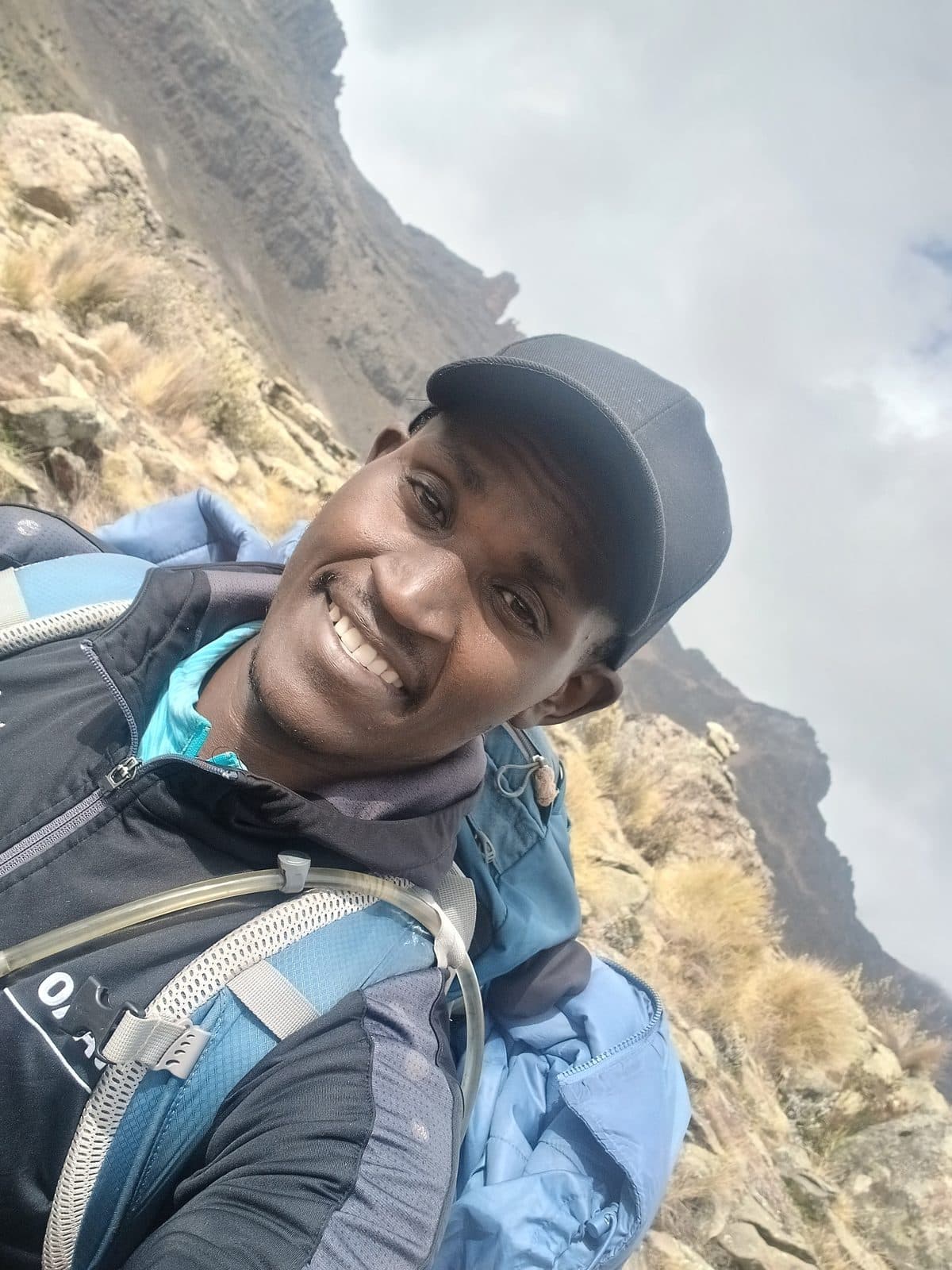 Selfie of a smiling guide on a misty rocky slope