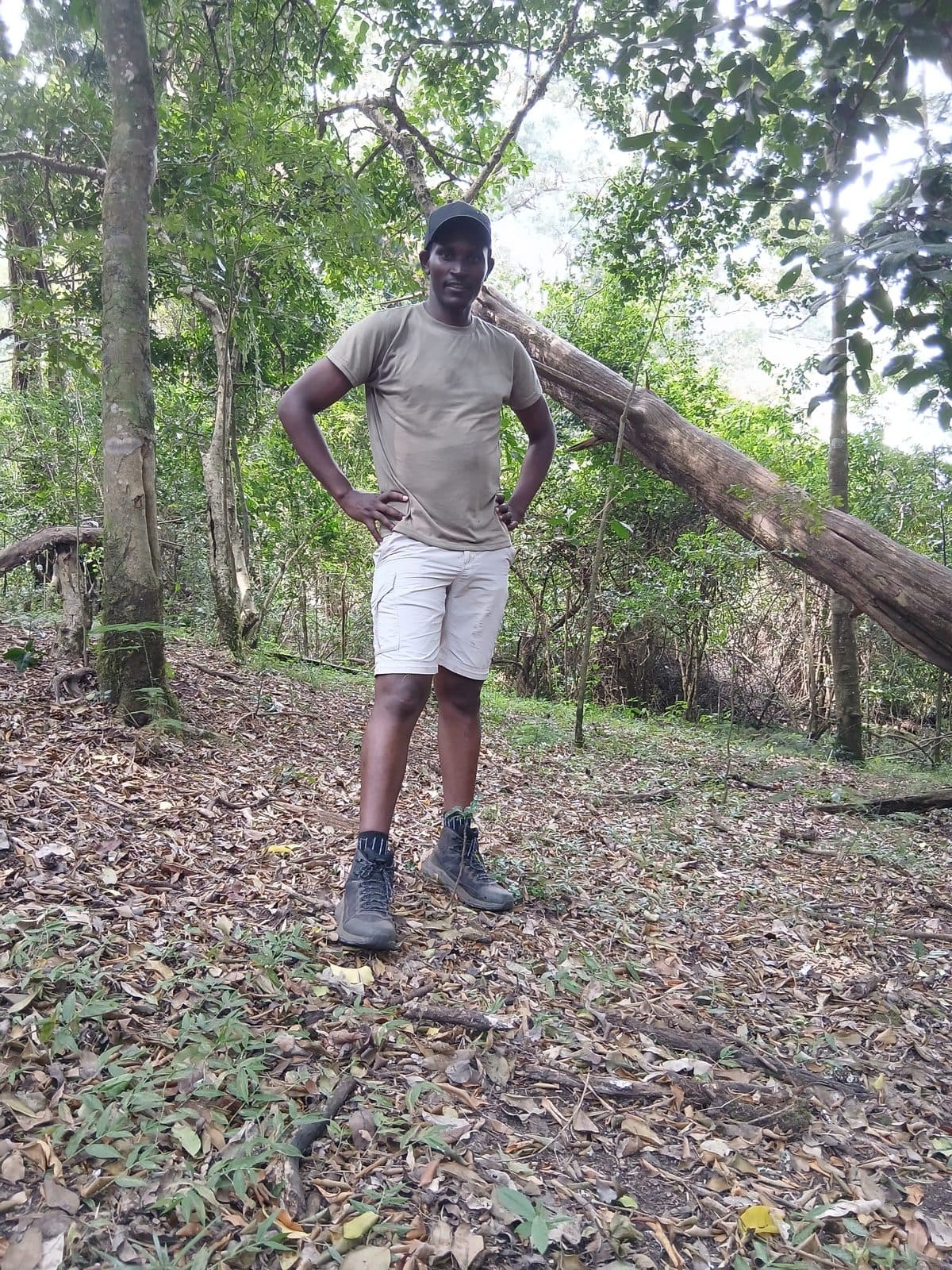 Guide standing in dry woodland with trees and leaf litter